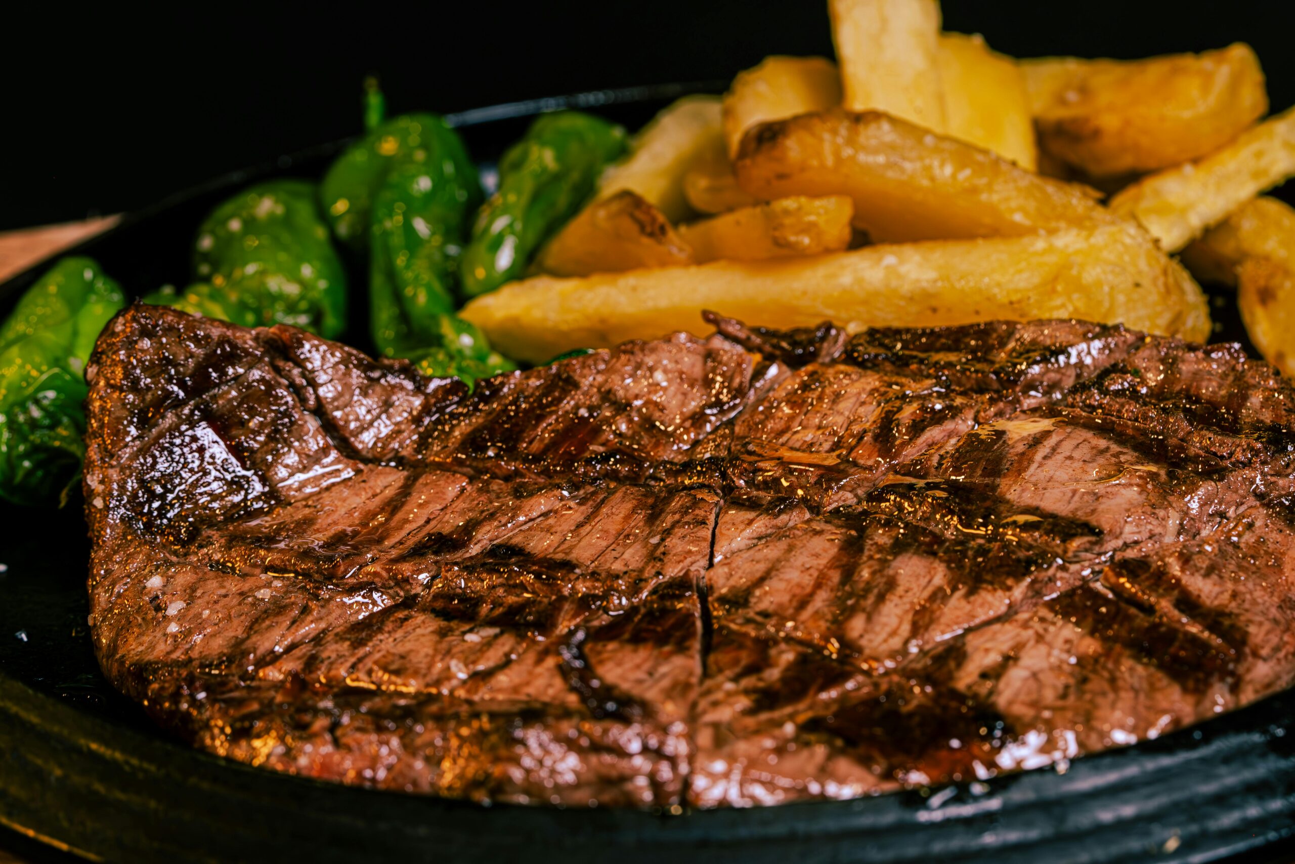Juicy grilled steak served with crispy french fries and fresh bell peppers.